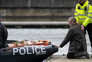 Beck crouches next to a boat containing the body of his wife in Silent Witness