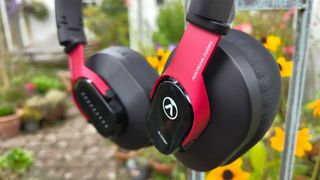 Austrian Audio Hi-X25BT over-ear headphones hanging up in garden in front of flowers