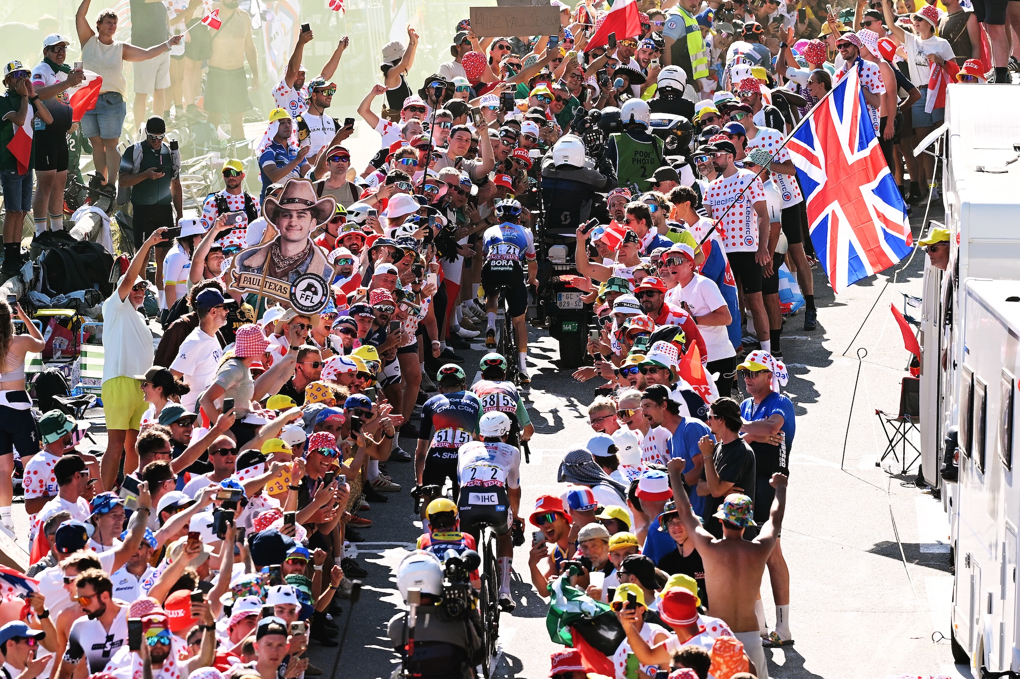 An overhead view of the crowds encroaching on the riders and Evenepoel stuck behind three motorbikes unable to attack past