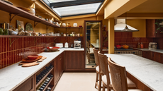 dark wooden kitchen with marble worktops, cola-colored tiles, open shelving and mustard-colored walls 