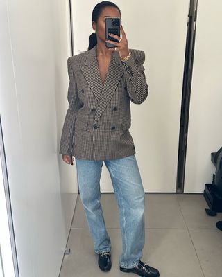 Woman wearing blazer and jeans.