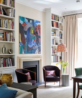 A white living room with a fireplace and tall bookshelves built into the walls