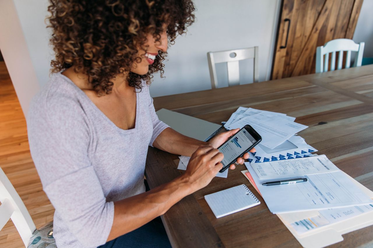 Woman Doing Finances at Home on Smart Phone