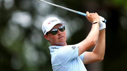 Ben Griffin plays an iron shot wearing sunglasses and a white cap