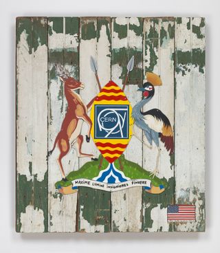 View of Maximum Luminosity, 2018, by Tom Sachs - a piece of wall art featuring distressed wood panels, an image of Uganda’s coat of arms in the centre and the American flag in the corner