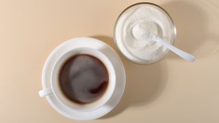 collagen powder besides a mug of black coffee