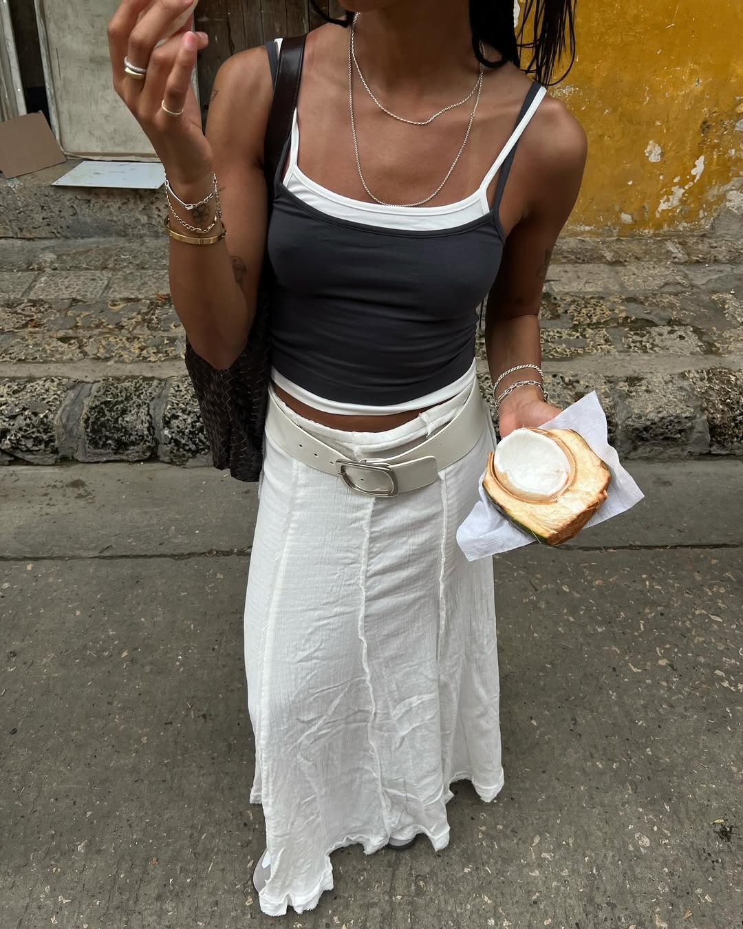 Influencer Amaka in a white skirt and double layered tank top.