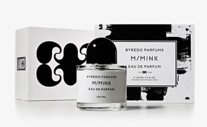 M/Mink perfume in a black and white bottle in front of the black and white boxes that it comes in. 
