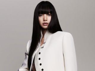 Lisa poses wearing a white Louis Vuitton jacket