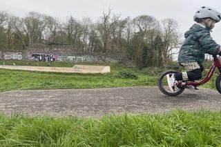 young boy too fast for his dad to capture an image of him riding the local pumptrack