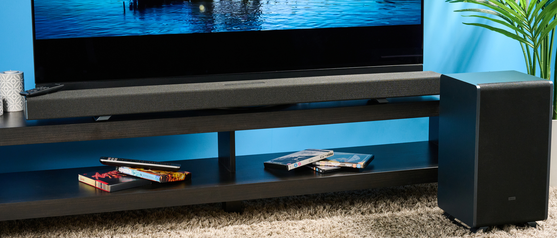 The Sharp 5.1.2 HT-SBW55121 Soundbar photographed in front of a TV and a blue background. 