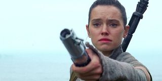 Rey holding lightsaber out in Star Wars: The Force Awakens