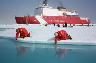 On July 10, 2011, Jens Ehn of Scripps Institution of Oceanography (left), and Christie Wood of Clark University (right), scooped water from melt ponds on sea ice in the Chukchi Sea during the NASA-sponsored ICESCAPE expedition.