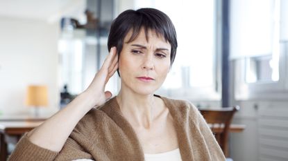 Woman experiencing tinnitus