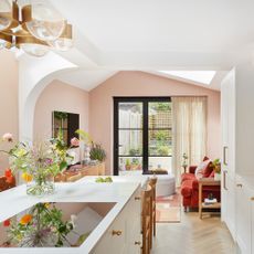 an open plan space with a kitchen, dining area and living area leading out to patio doors and a garden