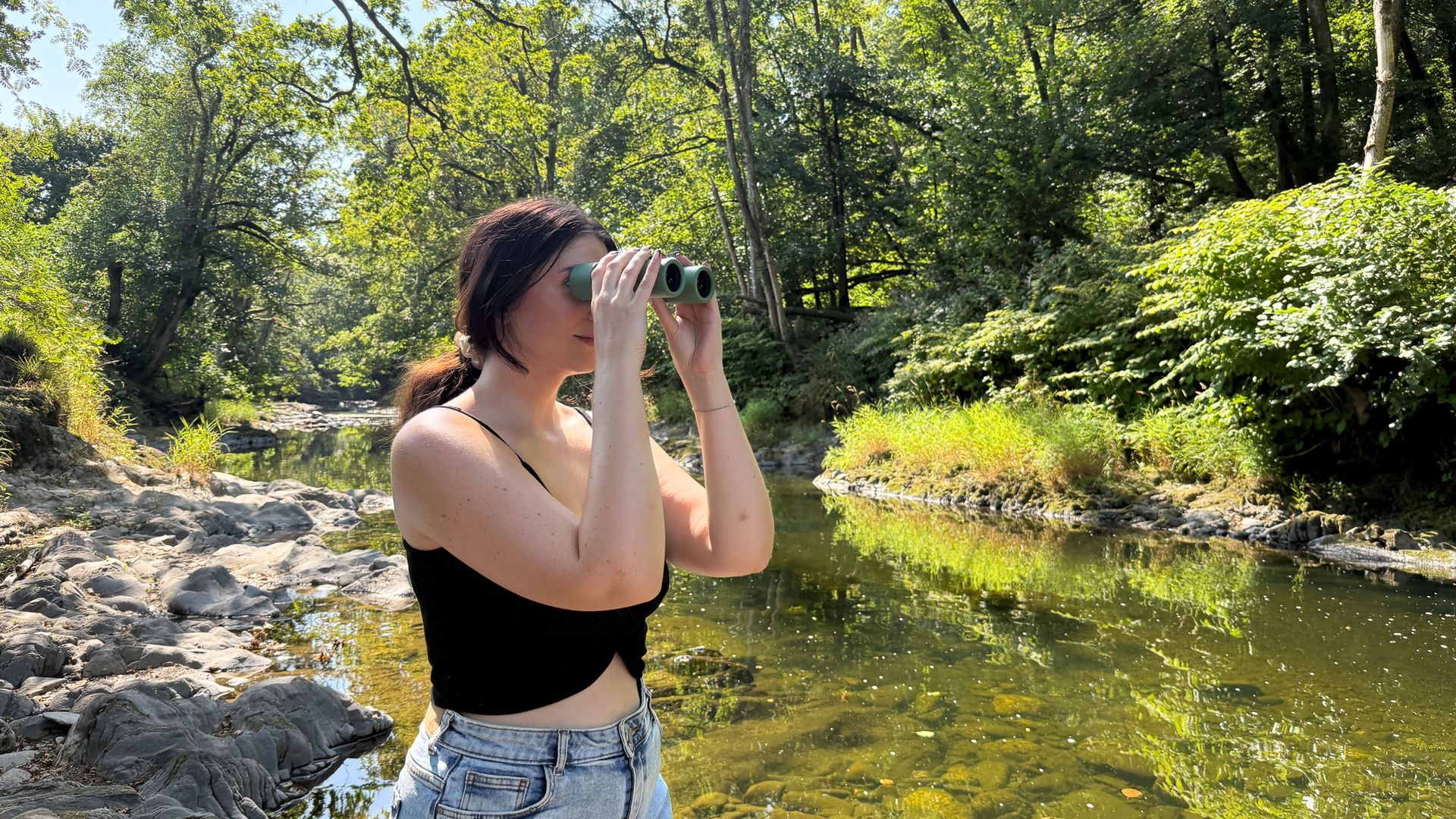 woman using the Swarovski CL Companion 8x30 by a river