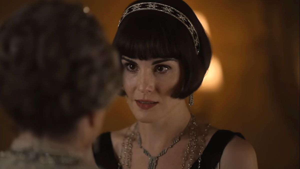 A concerned Michelle Dockery stands in the study while speaking with Dame Maggie Smith in Downton Abbey - The Movie.