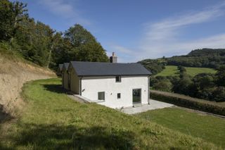 Built into the side of a shale hill, the cottage benefits from glorious views across the Welsh countryside. The aluminium pivot door added to the side of the house was on Amy’s ‘most-wanted’ wish-list from the beginning.