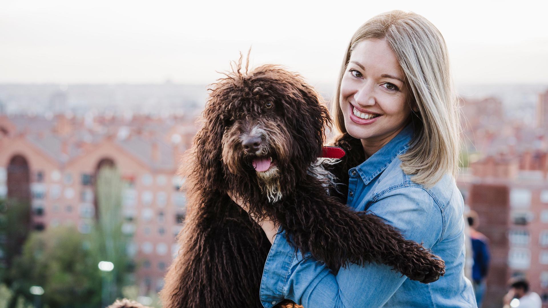 woman carrying big brown dog