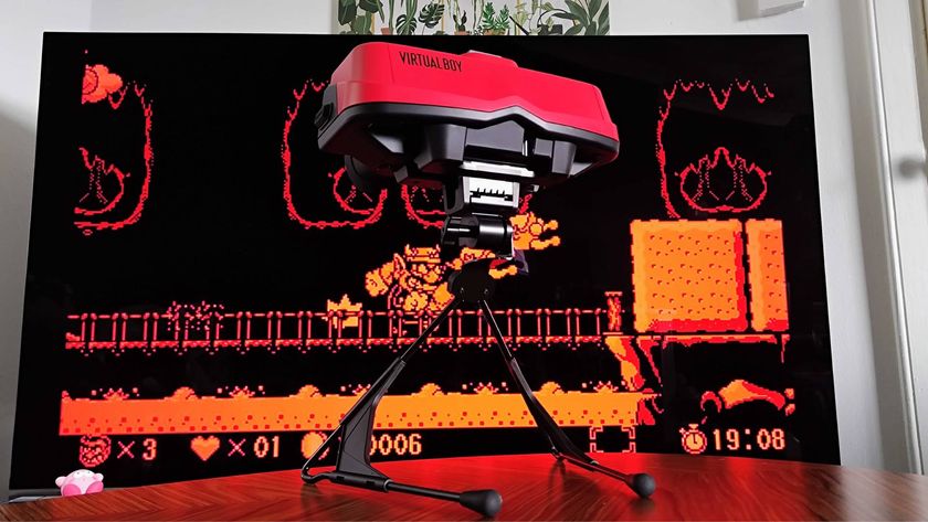 Switch Virtual Boy on woodgrain table with TV in backdrop and Virtual Boy Wario Land on screen.