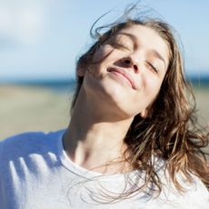 a woman on the beach smiling - best gradual tanners