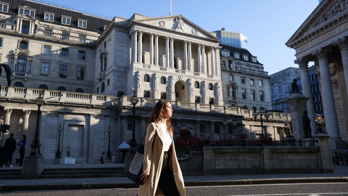 Woman walking in front of the Bank of England on a clear-sky Spring day