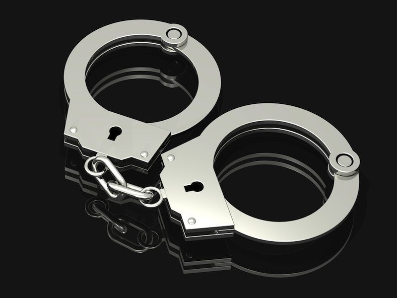 A pair of handcuffs on black background