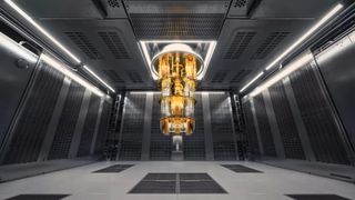 Gold quantum computer hangs from ceiling like a chandelier in a dark room.