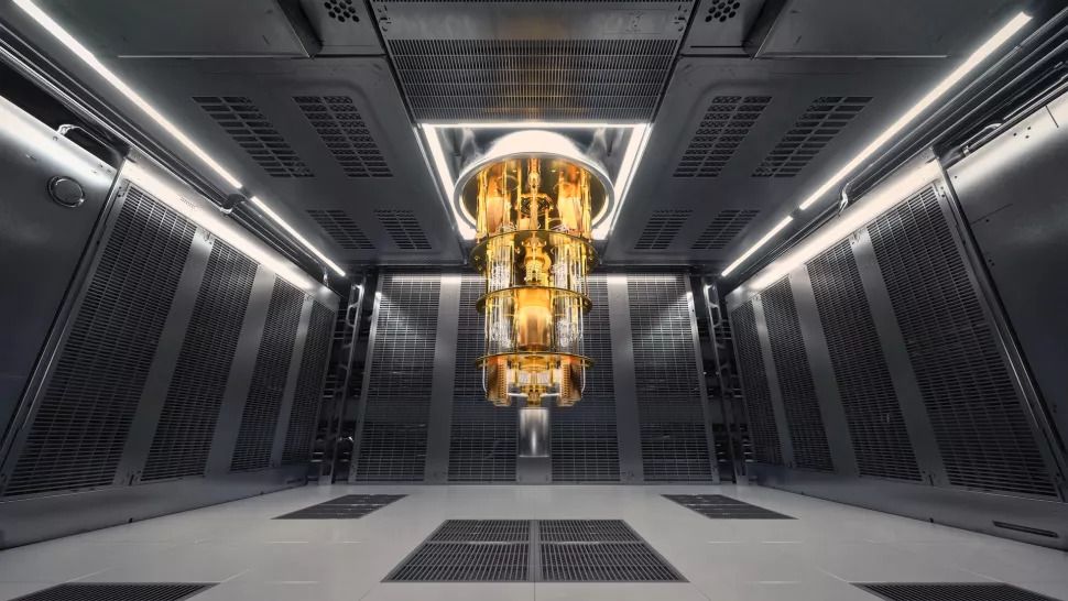 Gold quantum computer hangs from ceiling like a chandelier in a dark room.