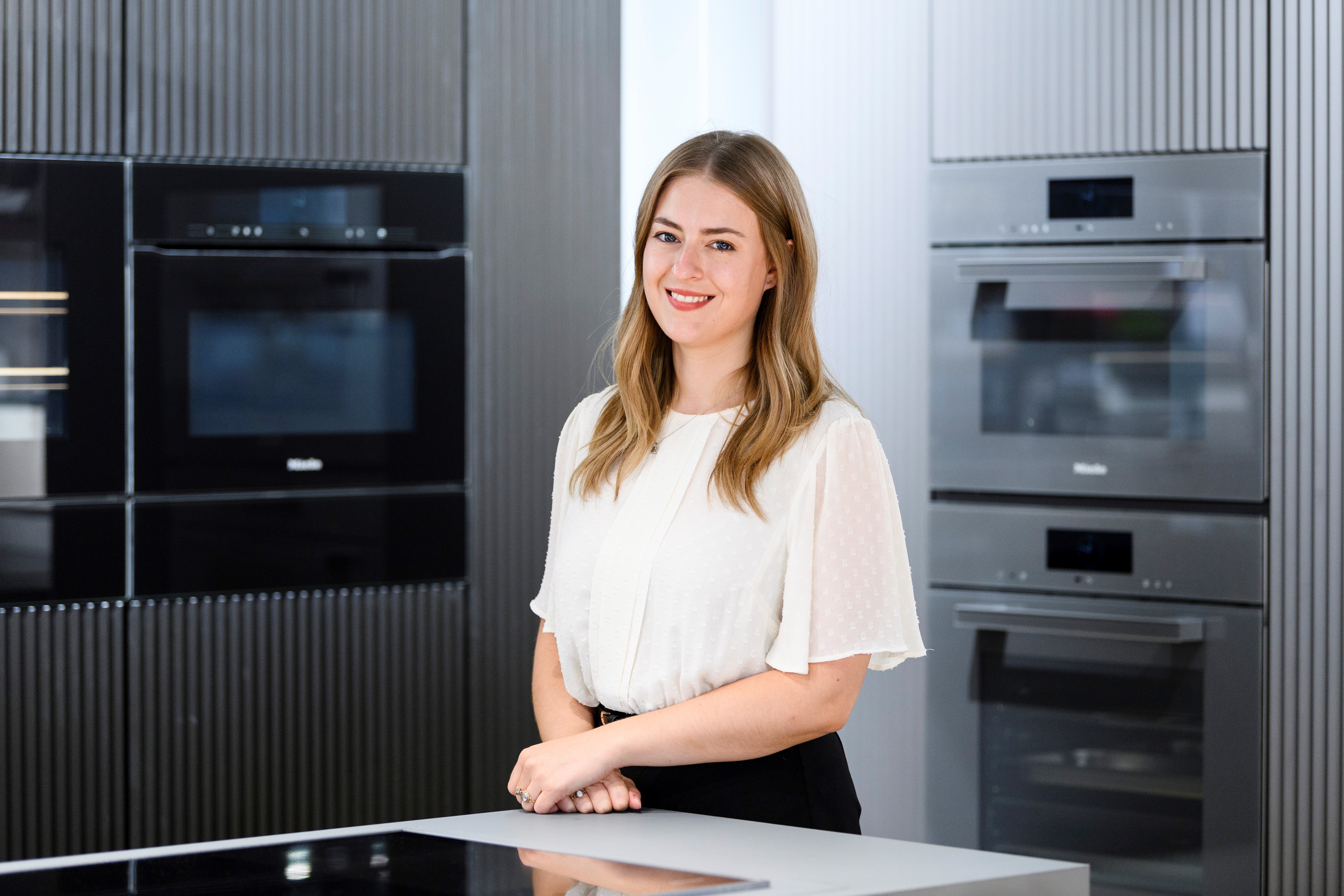 woman standing in a showroom with Mile appliances