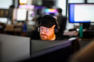 Lux Aeterna AI tools; a man looks at a computer monitor