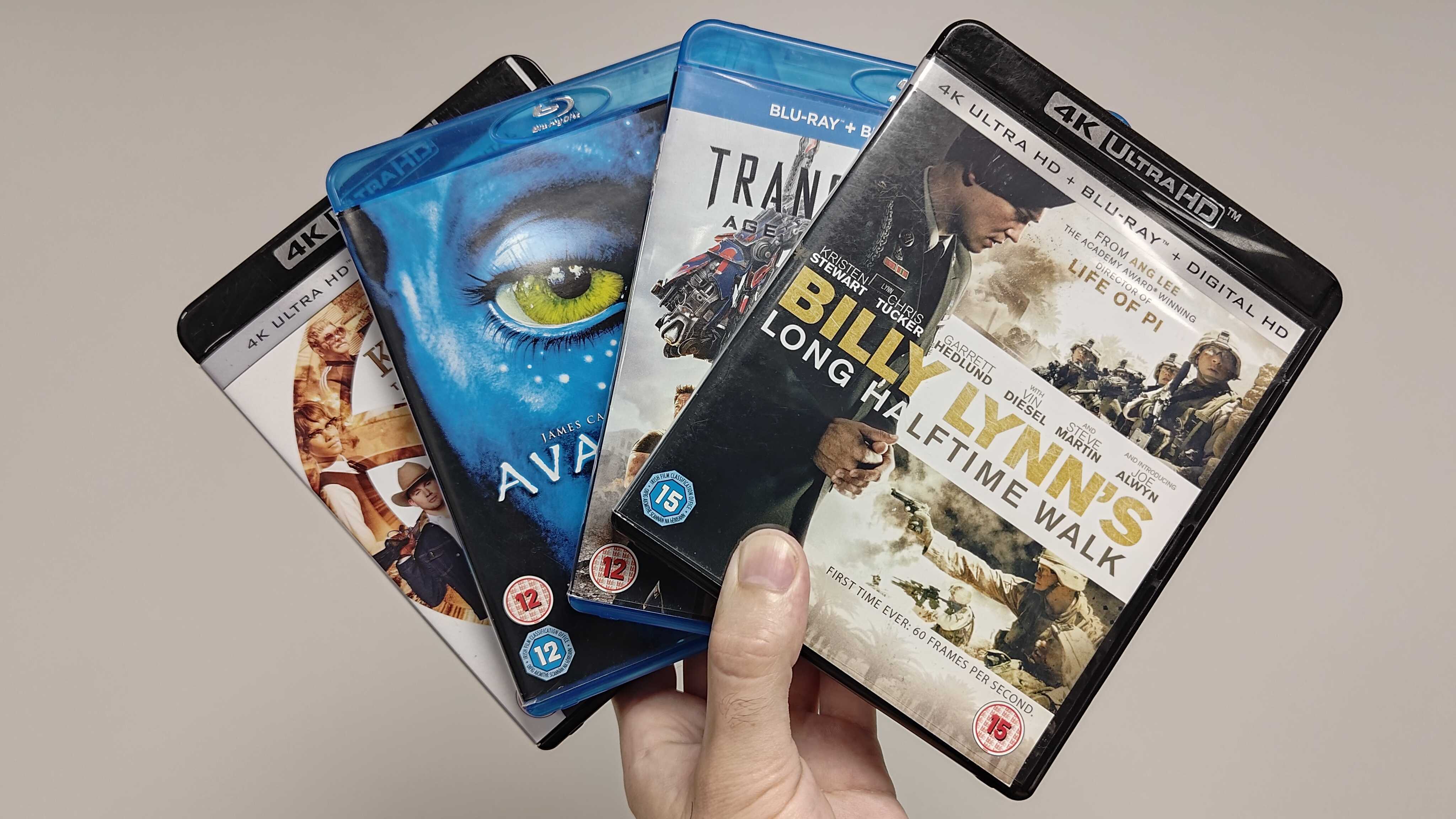 A hand holding Blu-rays of Billy Lynn's Long Halftime Walk, Transformers: Age of Extinction, Avatar and Kingsman: The Golden Circle