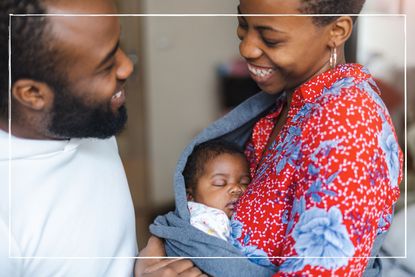 smiling parents cradle their baby