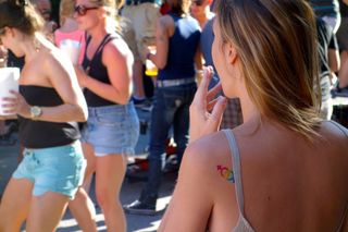 Photo of a woman with a tattoo on her shoulder, facing away from the camera