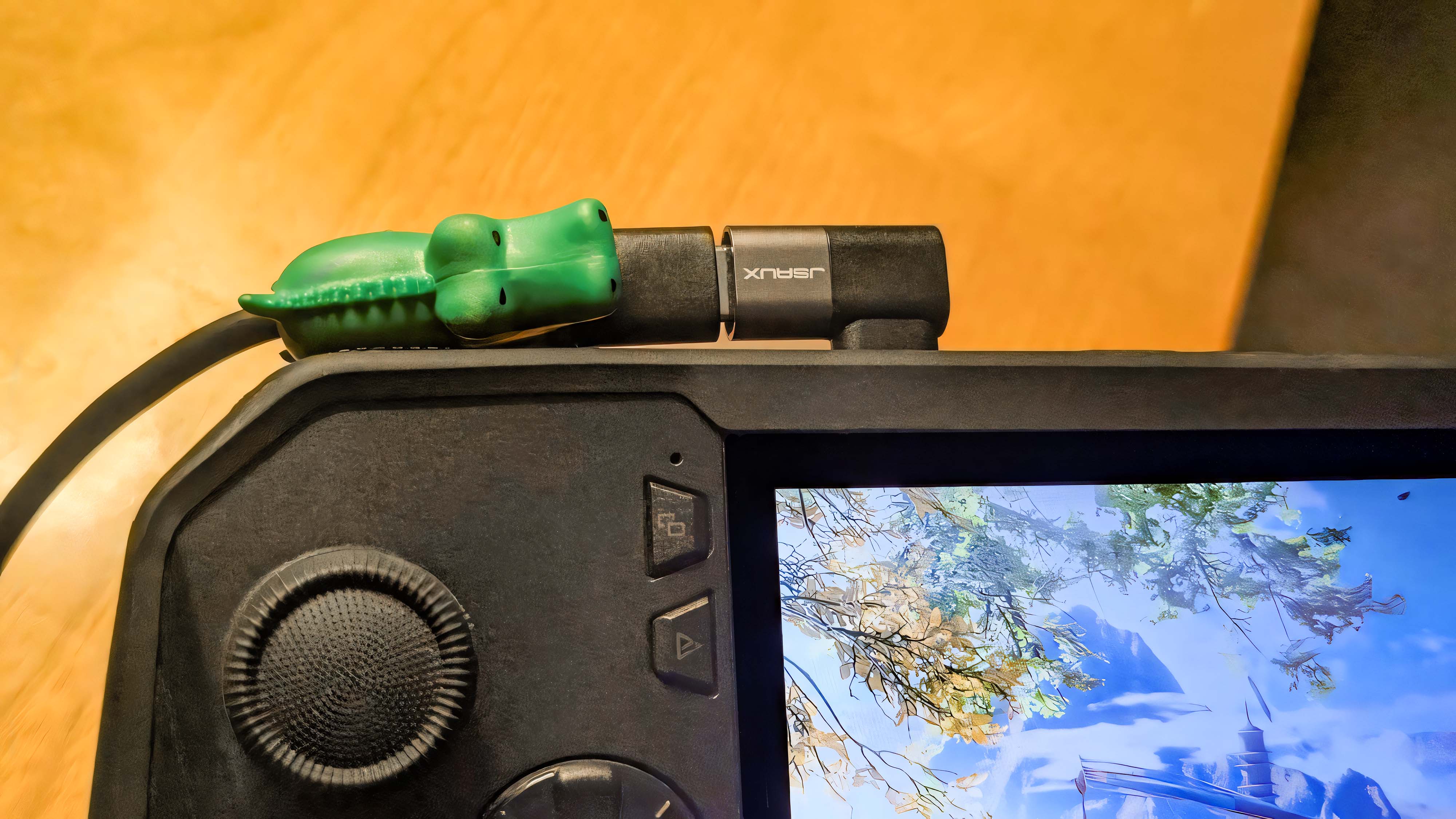 JSAUX right angle USB-C adapter connected to an ROG Ally X with a green alligator cable protector on the charging cable.