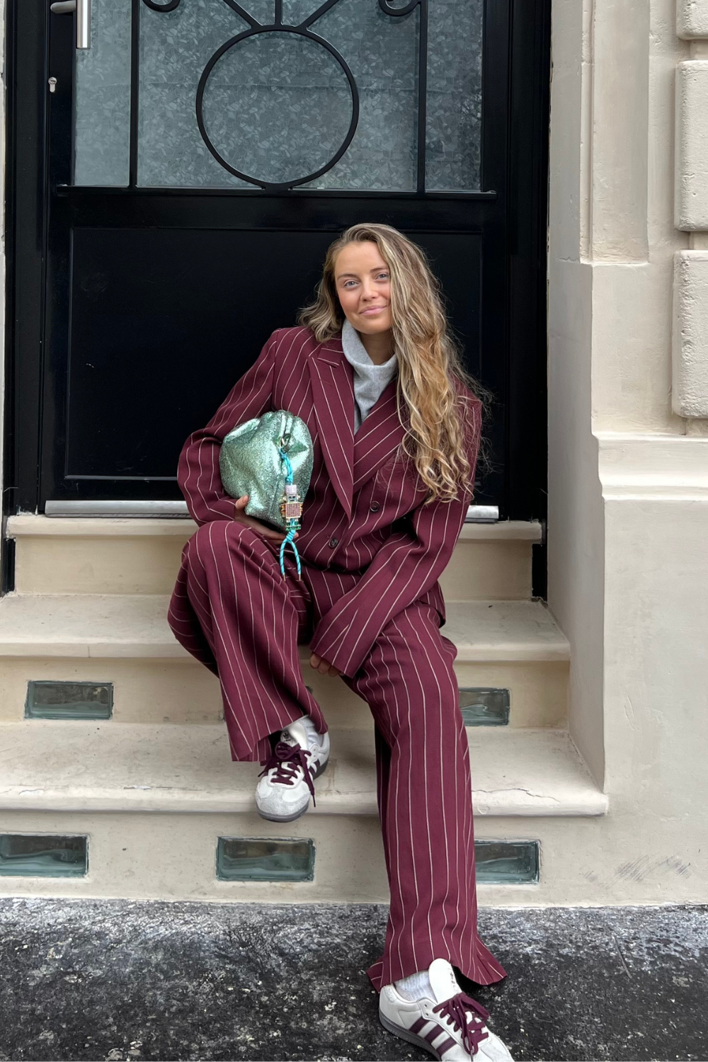 Lauren Cunningham wears burgundy Adidas Samba trainers and burgundy striped suit