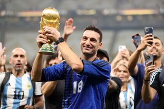 Argentina coach Lionel Scaloni holds the World Cup trophy aloft after victory over France at Qatar 2022.