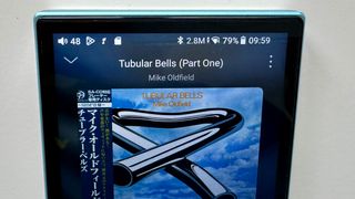 Display of the FiiO JM21 portable music player, showing Tubular Bells by Mike Oldfield