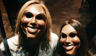 Two Purgers wearing creepy masks in The Purge.