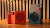 Small orange and black speakers on a wooden table