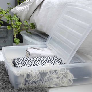 plastic storage containers with blankets inside