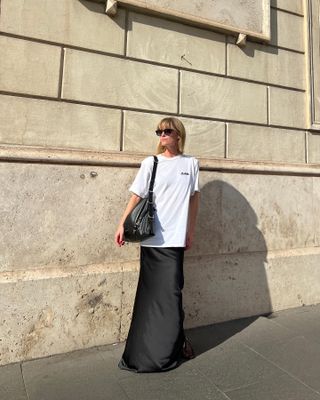 Jeanette Madsen wearing a T-shirt and black satin maxi skirt