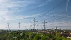Electricity pylons towering over nearby houses outside London, England.