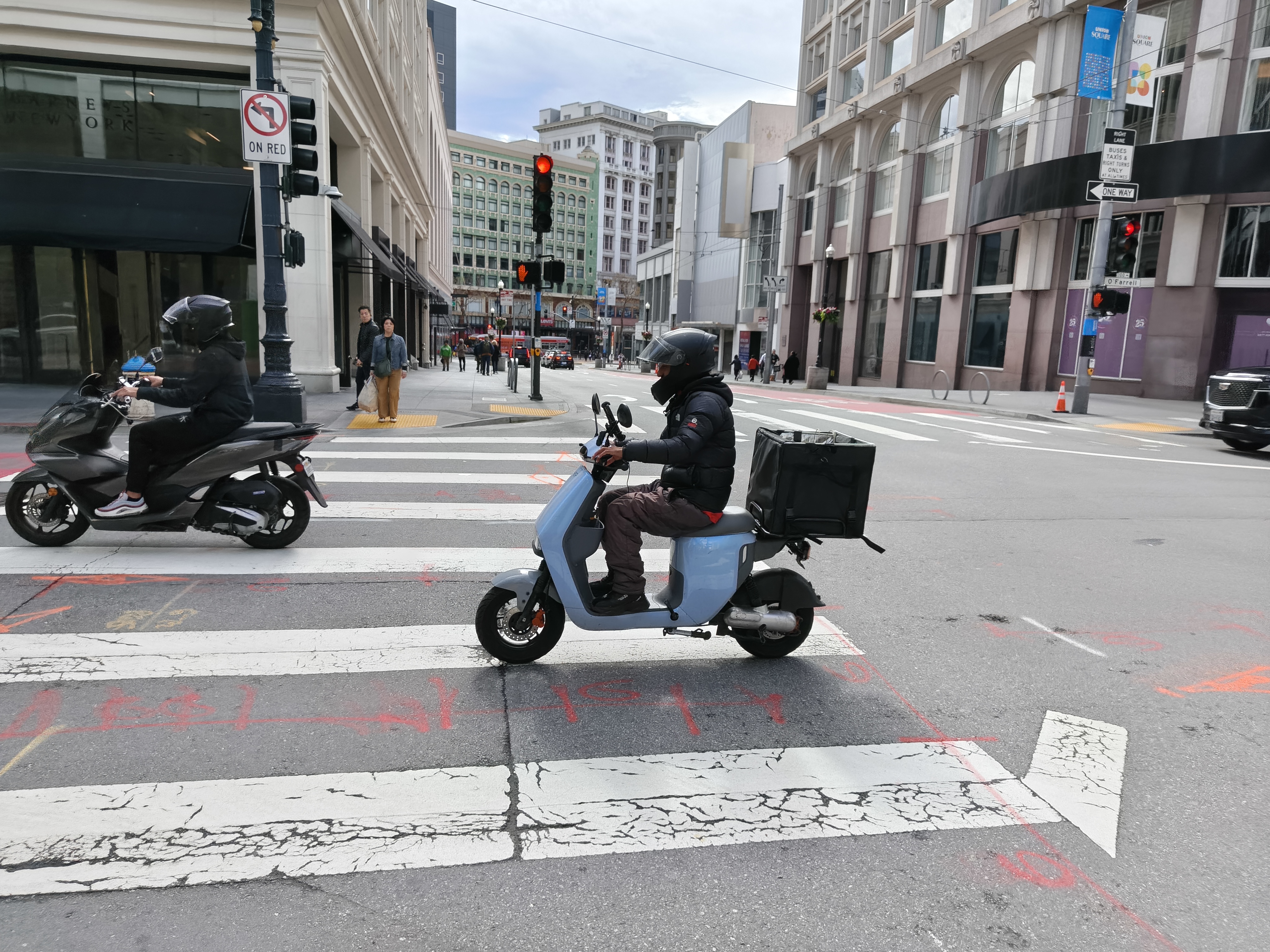 People riding scooters in the street