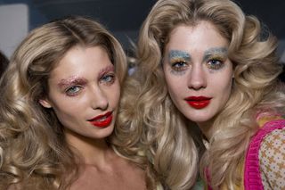 Two blonde models wearing glittery eye make-up