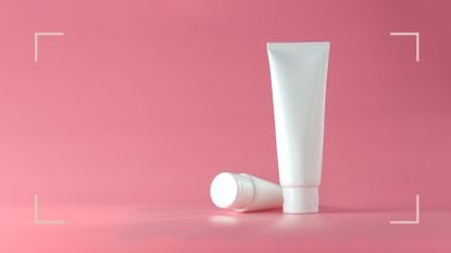 Two tubes of lactic acid vs glycolic acid skincare cream on a pink backdrop