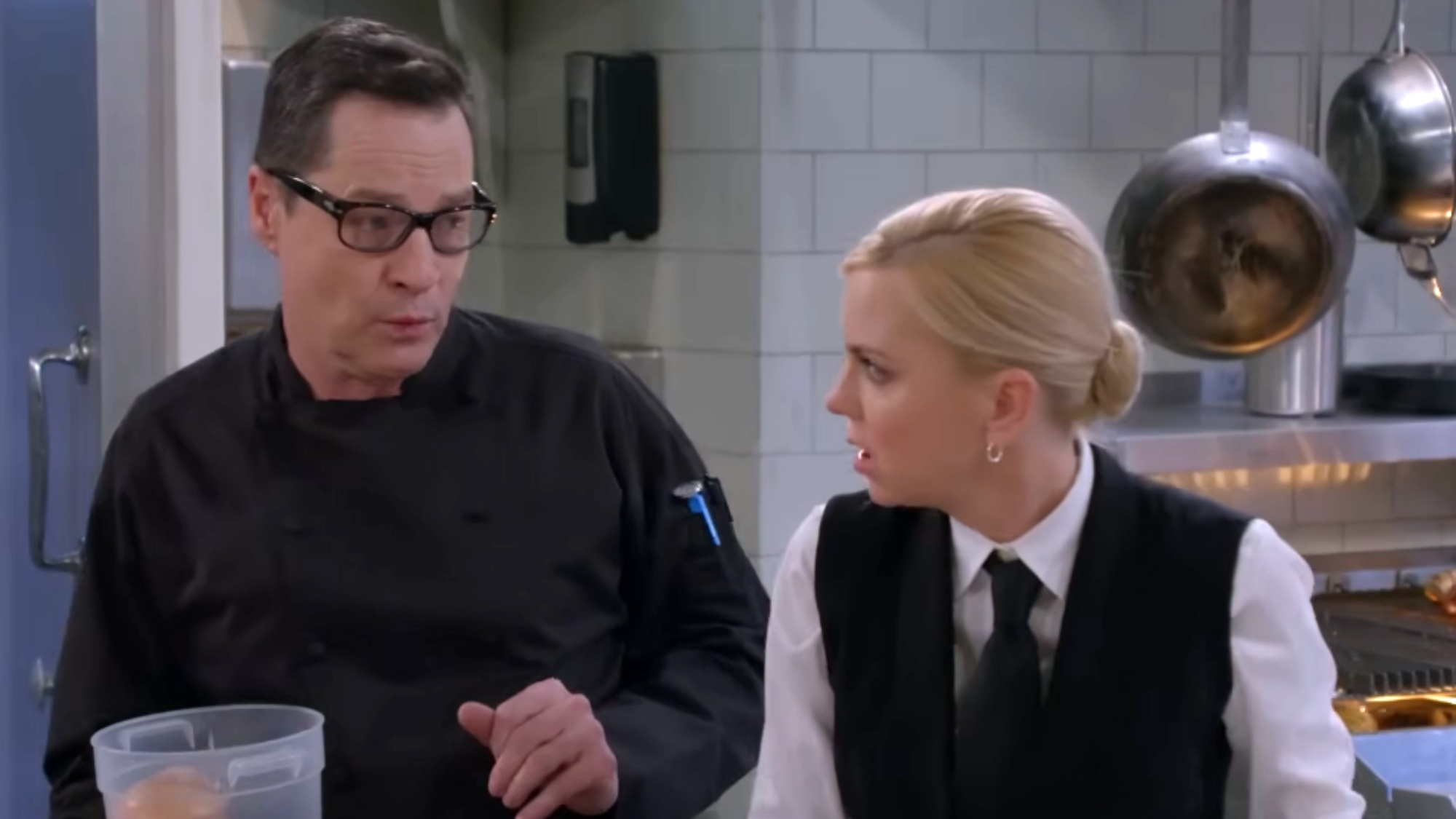 A screenshot of French Stewart and Anna Faris in a kitchen during an episode of Mom.