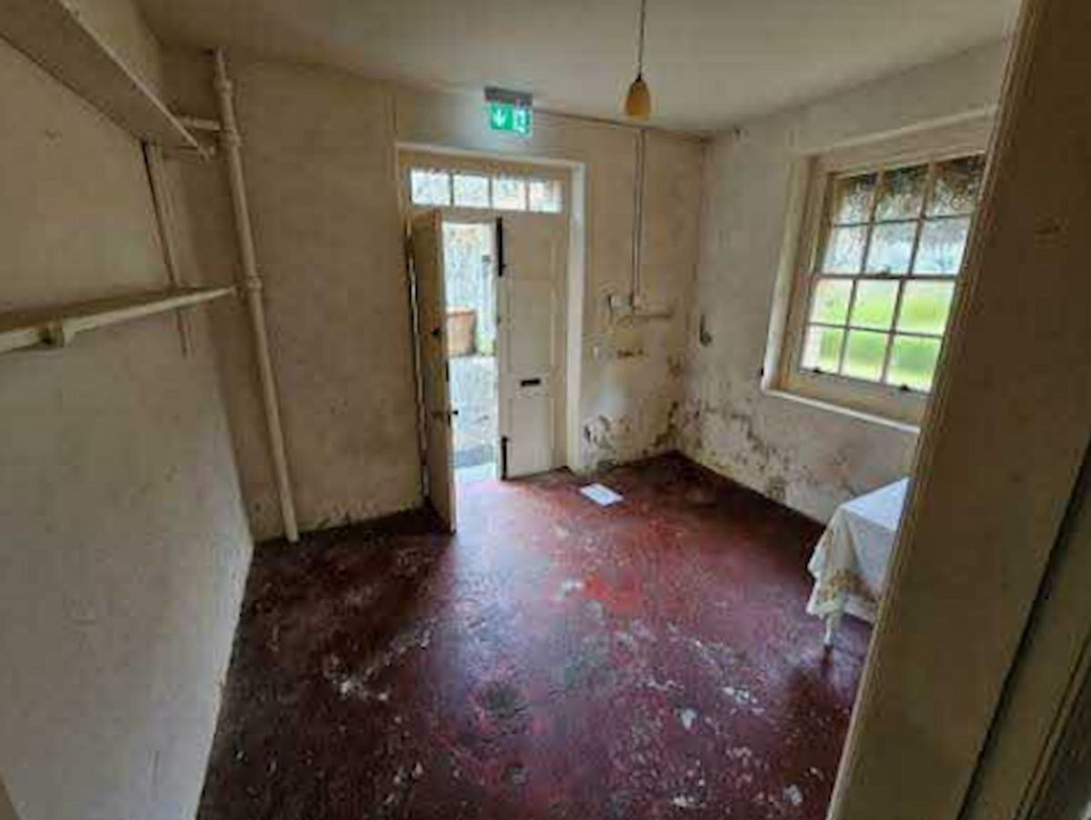 An unused rear room of a house that is empty and run down