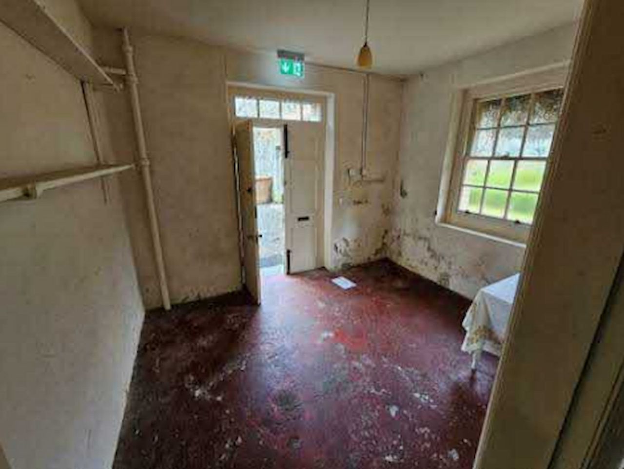 An unused rear room of a house that is empty and run down