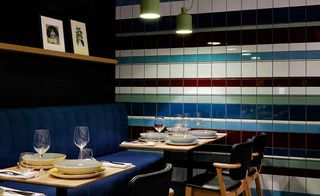 Blue booths & tables next to coloured tiled walls